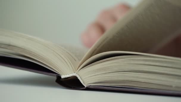 floue personne main flips pages de livre et exécute doigt sur lignes 