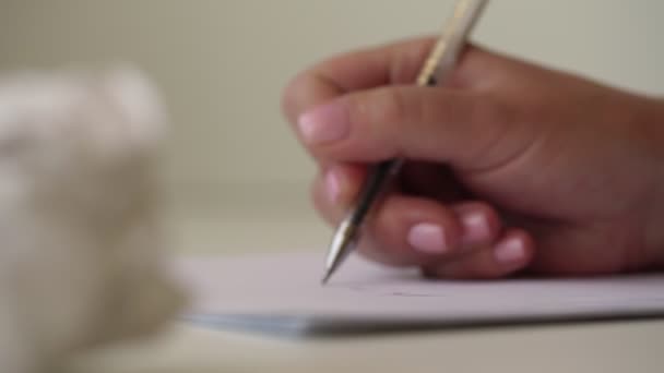 Молодая женщина рука пишет с кастрюлей на бумаге близкий вид сбоку — стоковое видео