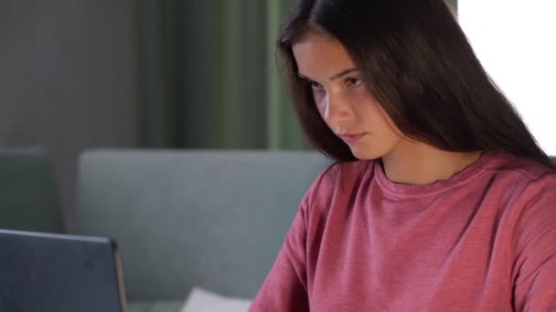 Brunette student in purple sweatshirt types on modern laptop — Stock Video