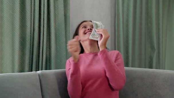 Молодая красивая женщина в свитере ловит падающие банкноты — стоковое видео