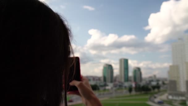 Brunette in zonnebril maakt panoramische foto van de moderne stad — Stockvideo