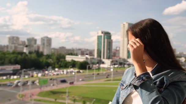 Glimlachende brunette houdt zonnebril en bewondert Cityscape — Stockvideo