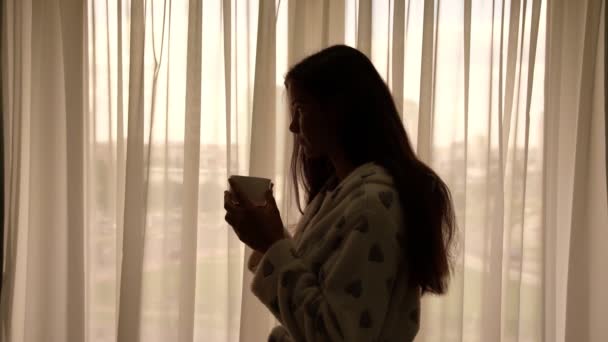 Mladá něžová žena s tmavými vlasy v županu na čaj — Stock video