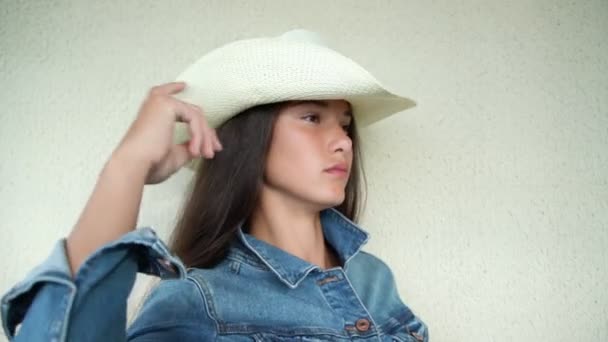 Chica con pelo oscuro en chaqueta de mezclilla y en sombrero de vaquero blanco — Vídeos de Stock