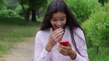 genç kadın akıllı telefon bakar ve mutluluk içinde atlar