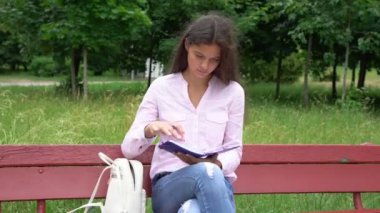 ciddi kız elinde kalem tutan mavi defter sayfaları döner