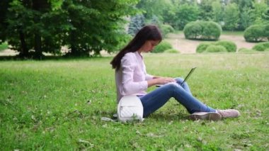 uzun saçlı esmer yeşil çim ve dizüstü bilgisayar da türleri oturur