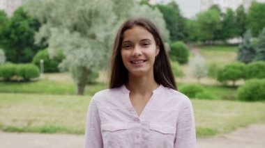 mutlu kız gülümsüyor ve beyaz çiçek açan ağaca karşı pozlar