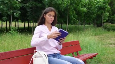 güzel bayan beyaz çanta açar ve mavi not defteri notlar yapar