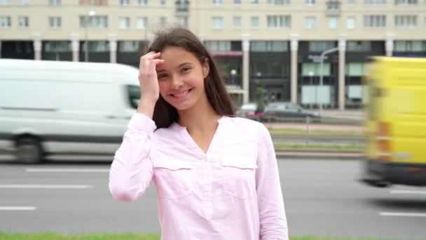 Brune souriante aux cheveux lâches pose dans la rue — Video