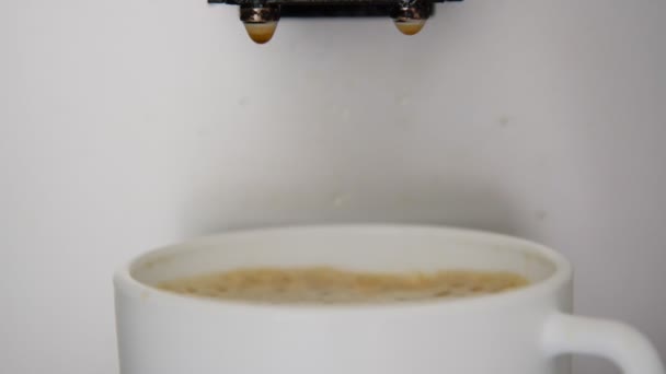 Gotas de café cair em branco copo cheio com espuma marrom — Vídeo de Stock