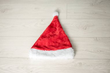 bir kırmızı noel baba şapka evde odada ahşap zemin üzerinde yatıyor