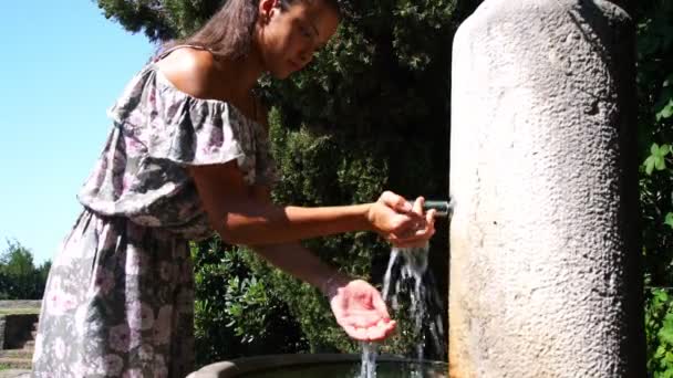 Fille appuie sur robinet sur la rue buveur pour boire de l'eau sous le soleil — Video