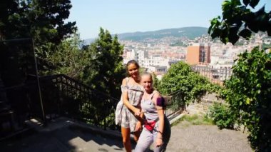 mutlu bayanlar manzara karşı monopod kullanarak selfie yapmak