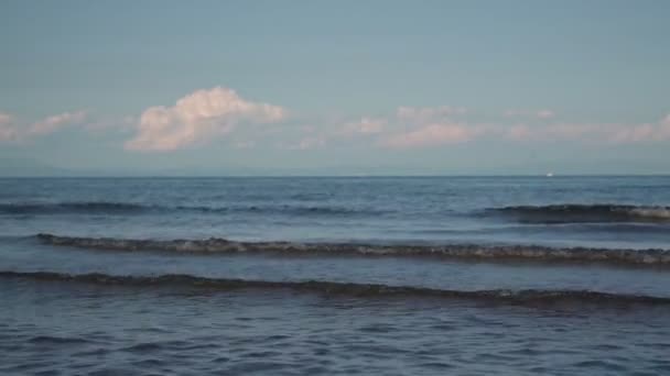 Безграничное глубокое синее море спокойные волны катятся по пляжу на закате — стоковое видео