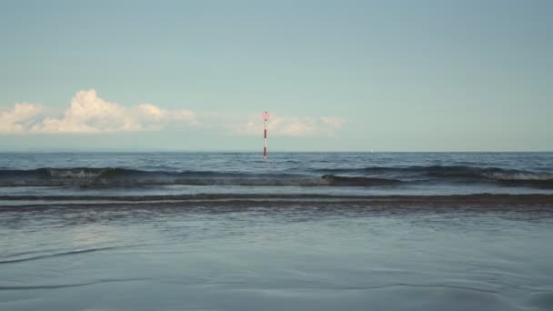 海の波は、ビーチで転がり、リゾートで人々の足を歩く — ストック動画