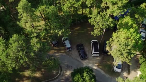 Automobiles parked in green garden at sunlight upper view — Stock Video