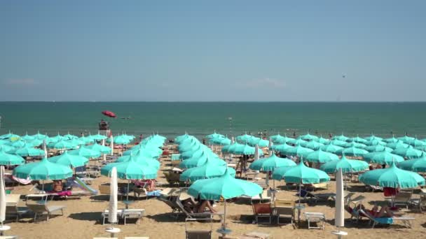 Playa con sombrillas de color turquesa contra el mar azul calma — Vídeos de Stock