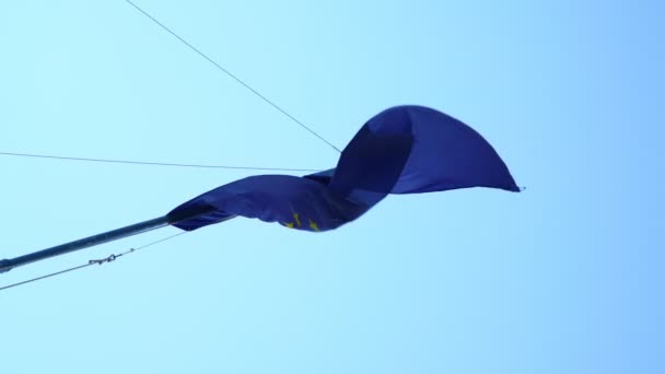 Bandera de la Unión Europea ondea en viento contra cielo azul claro — Vídeo de stock