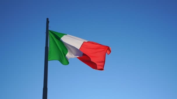 Italia bandera nacional ola en el viento bajo el cielo azul — Vídeos de Stock