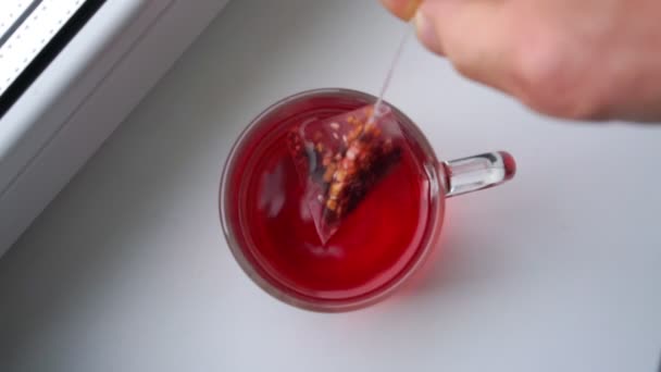 Вкусный малиновый чай, заваренный в большой стеклянной чашке — стоковое видео