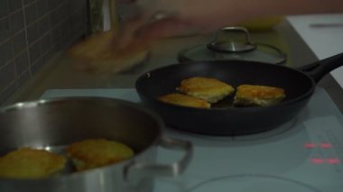 Kadın eli patatesli krepleri mutfaktaki metal kaba koyar.