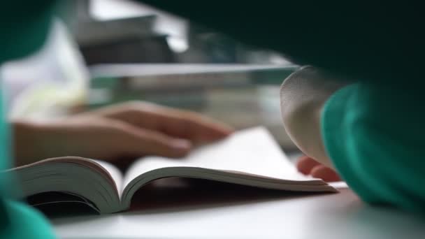 Estudante menina faz notas no livro com caneta vista extrema — Vídeo de Stock