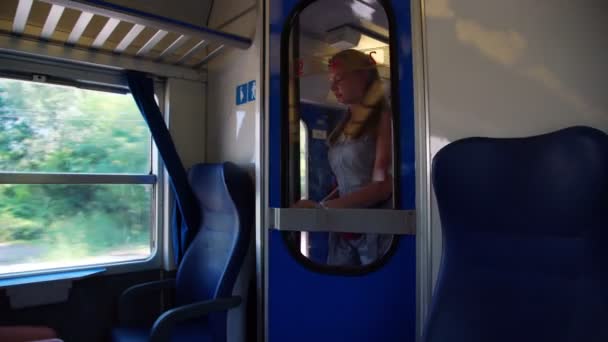 Bionda entra in carrozza e prende la chiamata in treno — Video Stock