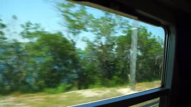 Country and sea landscapes change outside train window — Stock Video