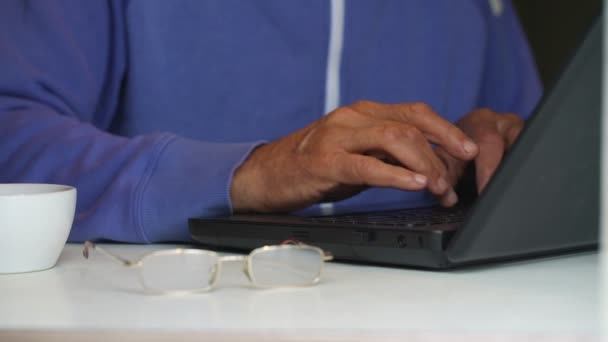 Tipi di vecchio sul computer portatile da tazza e occhiali sul primo piano tavolo — Video Stock