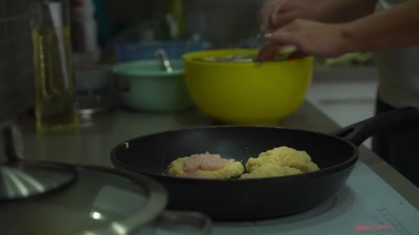 Hausfrau stellt Kartoffelpuffer-Tops auf Kochplatte — Stockvideo