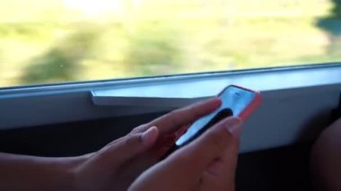 Kız el çırpıyor ve trende akıllı telefonları dinliyor.