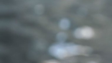 Parlak güneşli bulanık su dalgaları takip eder.