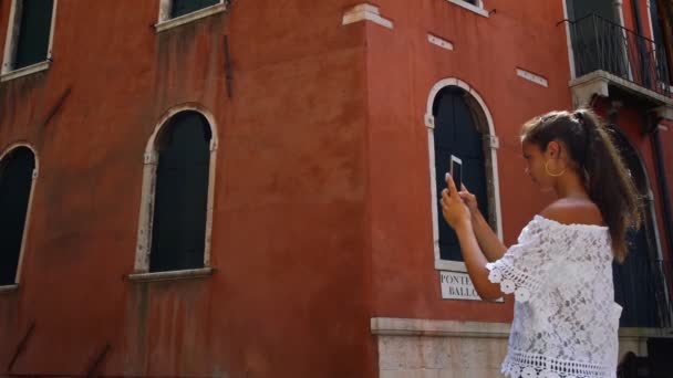 Adolescent fille prend des photos contre vieille maison vénitienne vue de près — Video