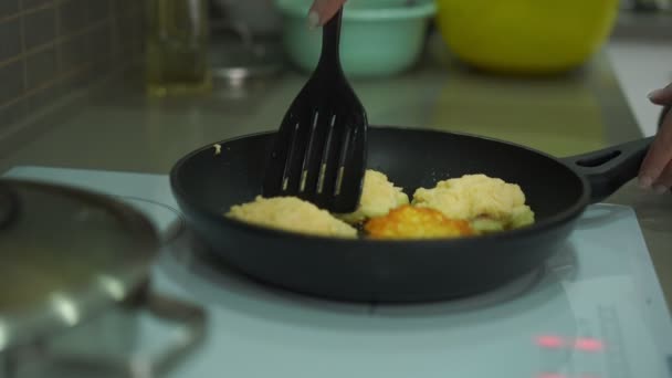 Kvinna hand vänder över potatis pannkakor på stekpanna närbild — Stockvideo
