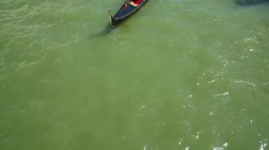 gondol Venedik 'te kanal yeşil su yüzeyinde süzülüyor