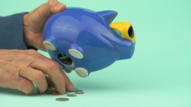 Yaşlı insanların elleri para kutusundan çeşitli madeni paralar çıkarır.