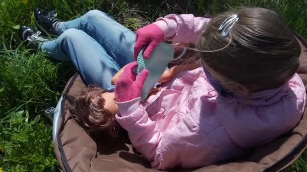 Jongedame in wegwerpmasker en handschoenen bedekt poppengezicht — Stockvideo