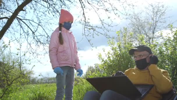 Mädchen steht neben sitzendem alten Mann und spricht im Frühlingsgarten — Stockvideo