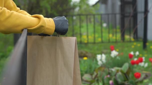 Mãos de pessoa em luvas estéreis pretas levar saco de papel marrom — Vídeo de Stock