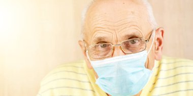 Tek kullanımlık gözlüklü yaşlı adam ve evde kazak.