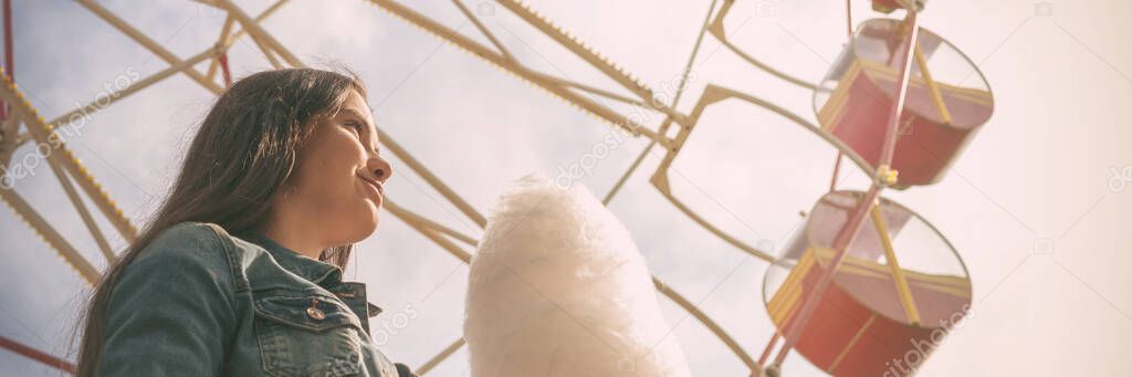 young woman with long loose flowing hair holds cotton candy