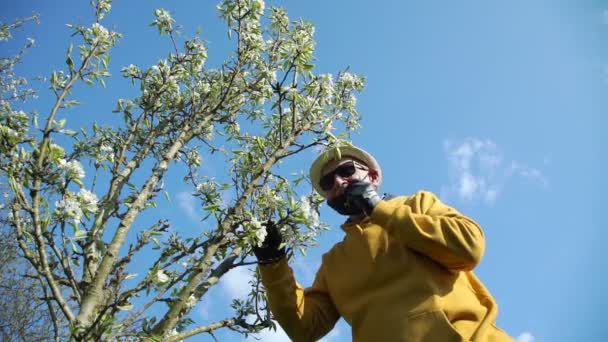 Pensionista quita máscara negra huele flores bajo el cielo azul — Vídeos de Stock