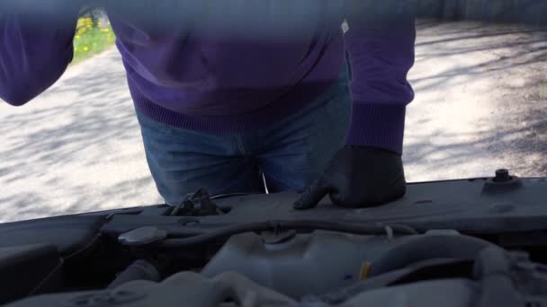 Persoon in zwart handschoenen kijkt in open voertuig kap sluiten — Stockvideo