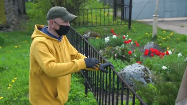 Γέρος με μάσκα και γάντια παίρνει χάρτινη σακούλα με προϊόντα — Αρχείο Βίντεο