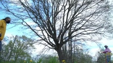 Siyah maskeli yaşlı adam scooter süren genç bayanı selamlıyor.