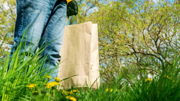 Person Hand in schwarzen sterilen Handschuh nimmt braune Papiertüte — Stockfoto