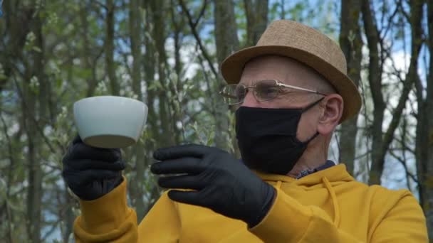 Anciano hombre en negro guantes toma taza persona vierte agua — Vídeos de Stock