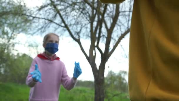 Meisje in roze trui masker handschoenen speelt bal met opa — Stockvideo