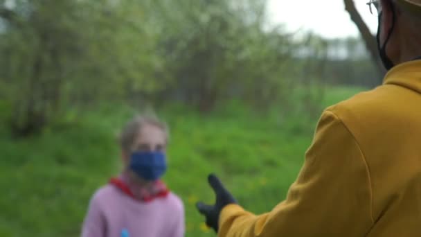 Дід і онука в масках і рукавичках грають в м'яч — стокове відео